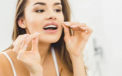 Woman flossing teeth in bathroom dental cleanings in Clearwater, FL